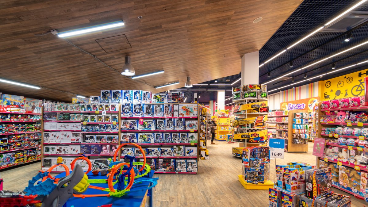 Toy store sales floor with LINK linear lights on a wooden ceiling