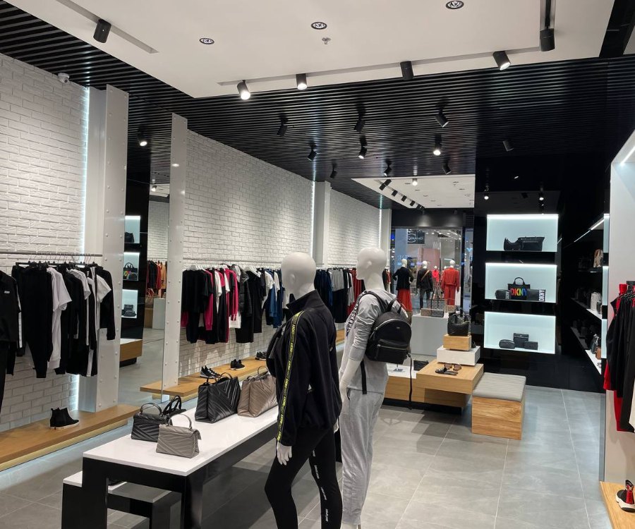 Wall fixtures with clothing under SHOOTER-L spotlights at DKNY