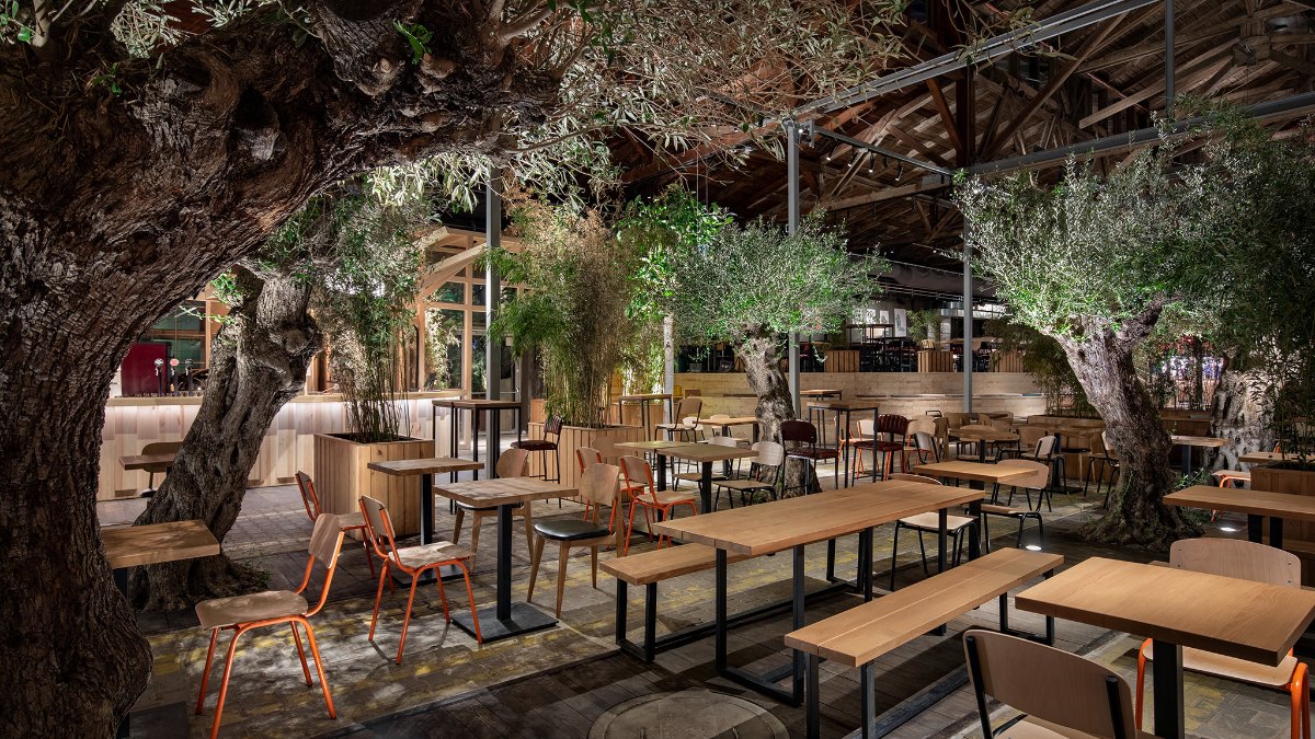 Tables among olive trees at the Gleis//Garten food market