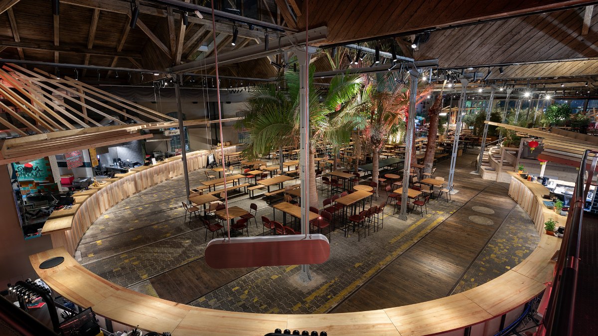 Gleis//Garten food court in Vienna with trees and a timber roof