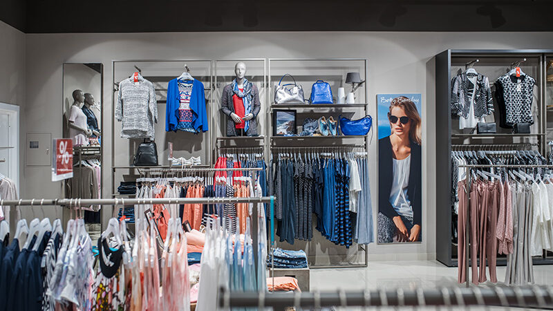 Wall of clothing, bags and mannequins in the Betty Barclay shop, Kyiv, under track spotlights