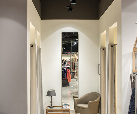 Fitting room area in the Betty Barclay shop with a track spotlight above the mirror