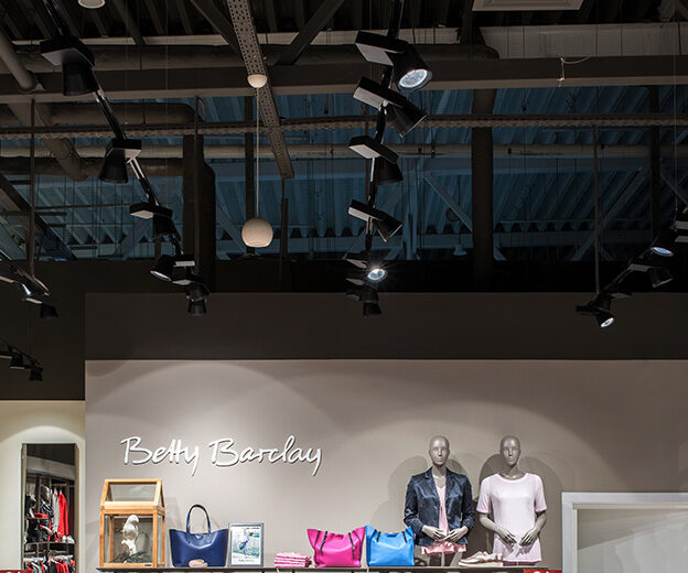 BAND track spotlights on rails above the Betty Barclay brand wall with mannequins