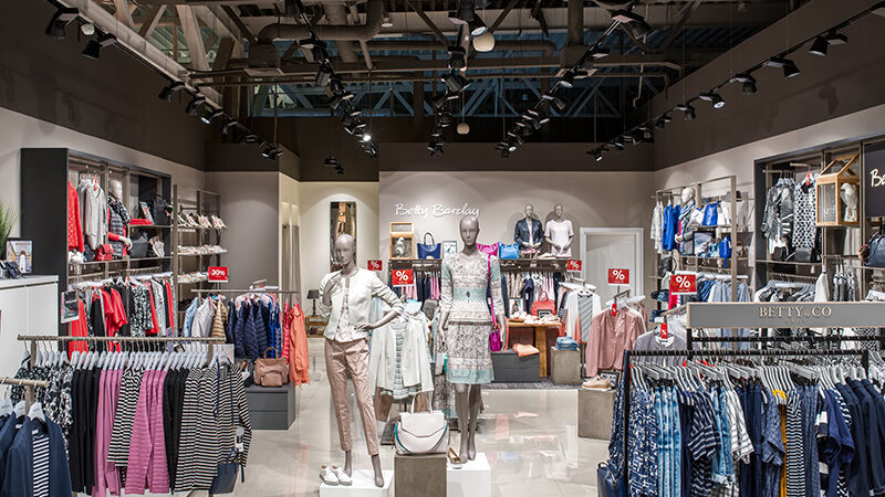 Betty Barclay sales floor in Kyiv with mannequins and clothing rails under BAND track spotlights