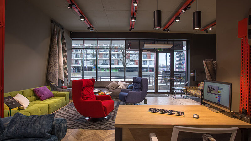 Blanche showroom in Warsaw with sofas and armchairs under BAND track spotlights on red rails