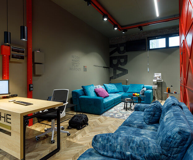 Area with turquoise sofas in the Blanche showroom, track spotlights and WIRE pendants