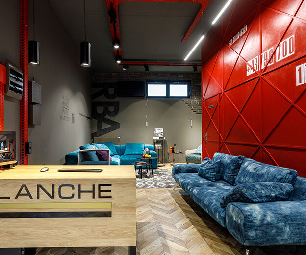 Blanche reception desk and red wall in the furniture showroom in Warsaw
