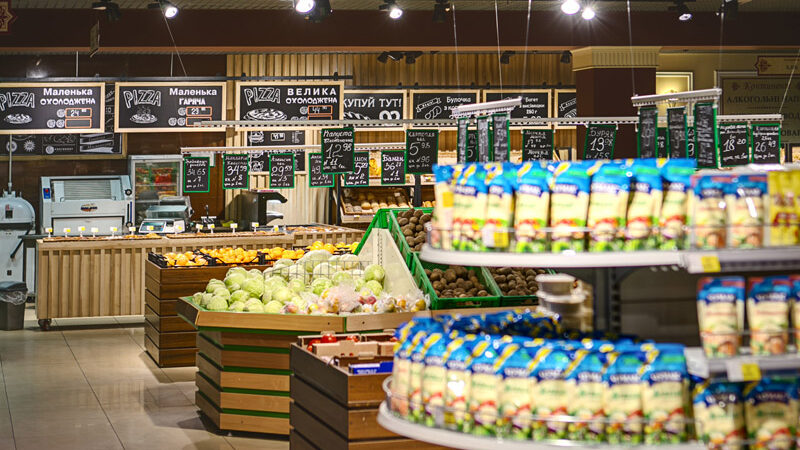Овощи, орехи и стеллажи с продуктами в супермаркете Континент