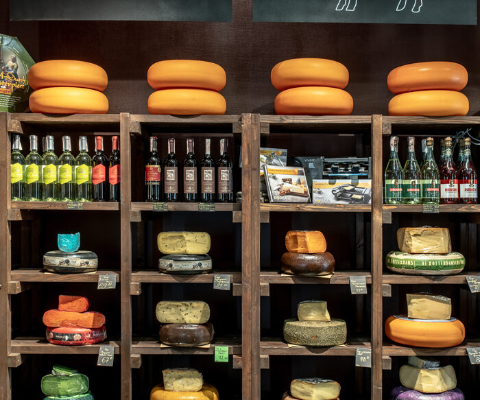 Shelves with cheese wheels and wine in the Cheese Kingdom shop