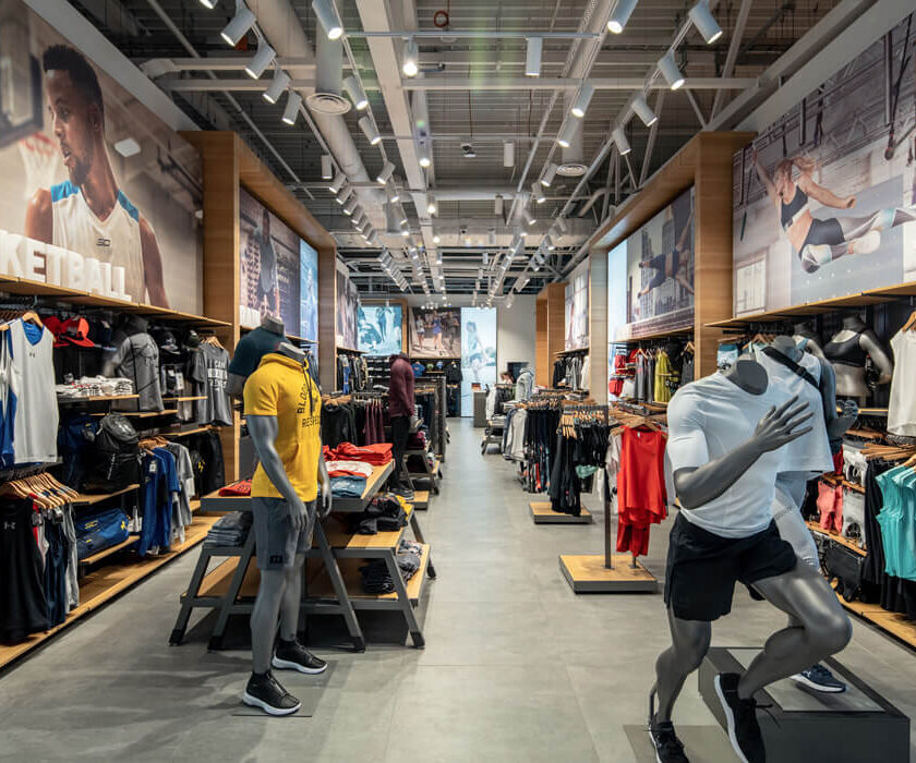 Центральный проход магазина Under Armour с рядами трековых светильников SHOOTER