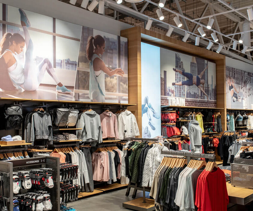 Пристенные стеллажи с худи и куртками в магазине Under Armour