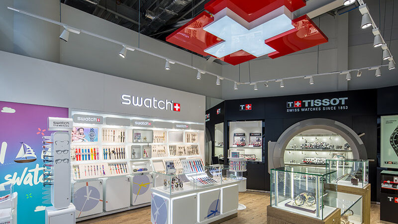 Торговий зал Zifferblatt у ТРЦ Lavina з трековими прожекторами над вітринами Swatch і Tissot