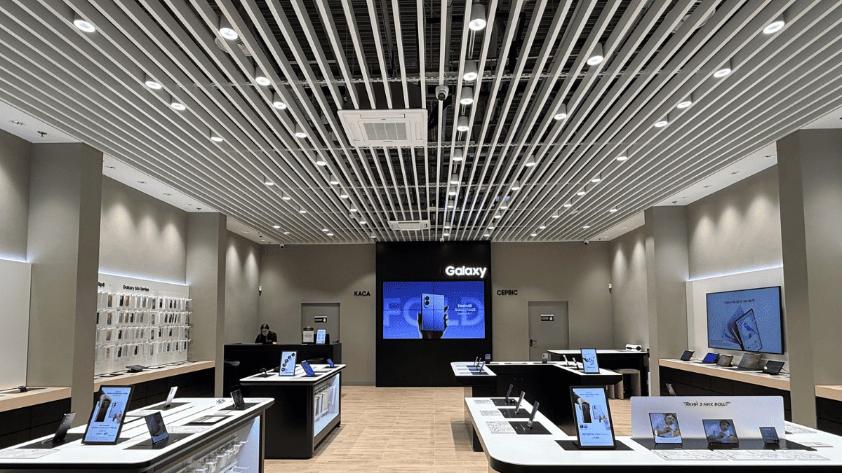 Sales floor of the Samsung brand store at Retroville with demo tables under a slatted ceiling