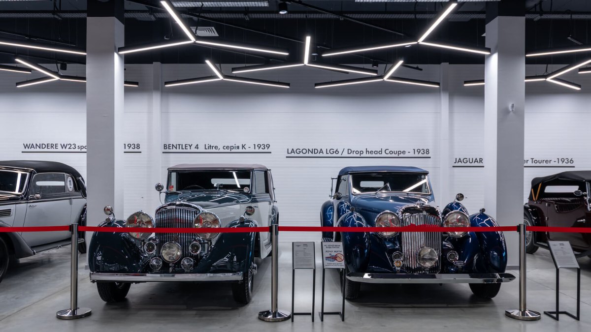 A row of classic cars in the VIKCARS hall under linear light